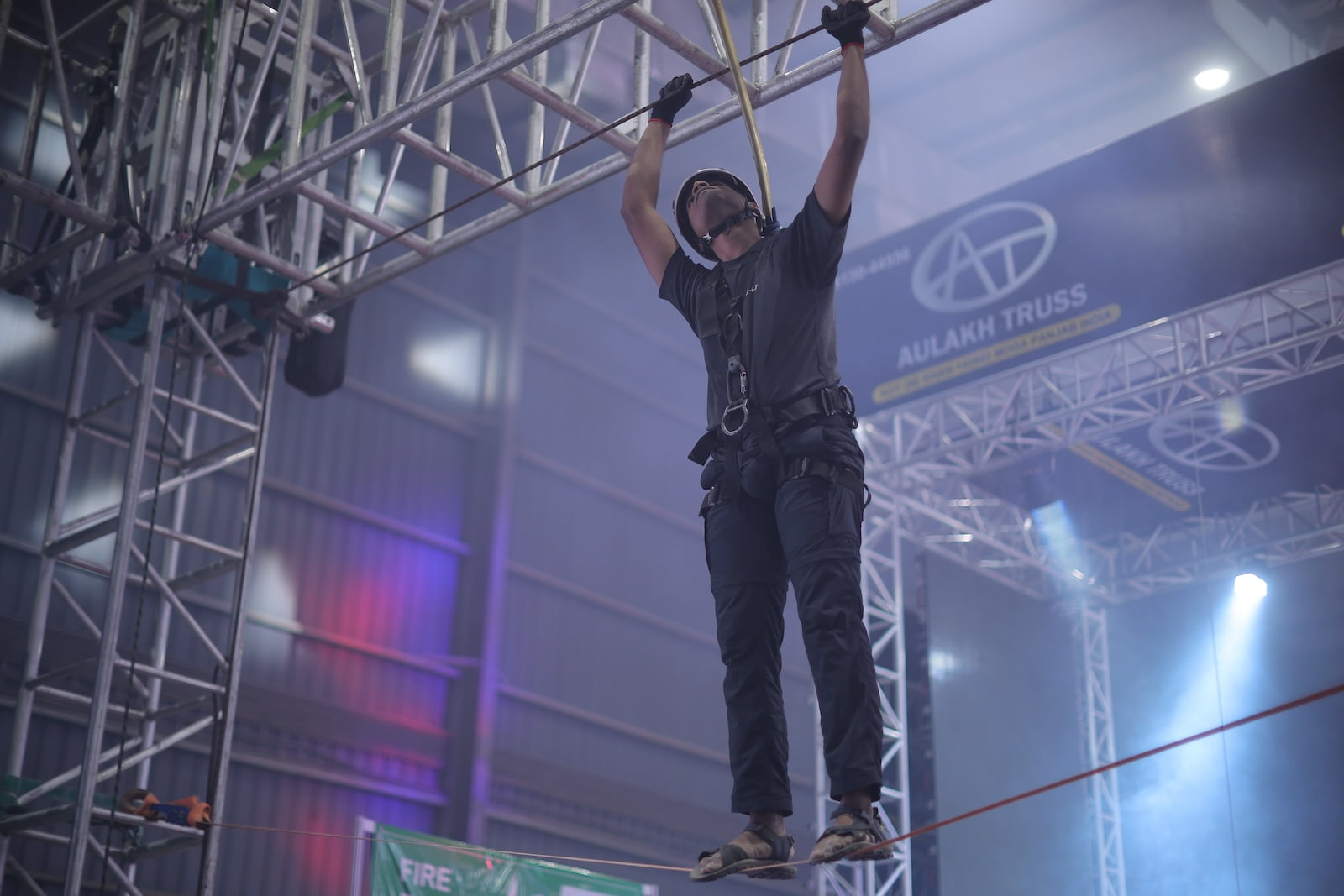 Stage rigging specialist working at height during safety demonstration at PALM Expo