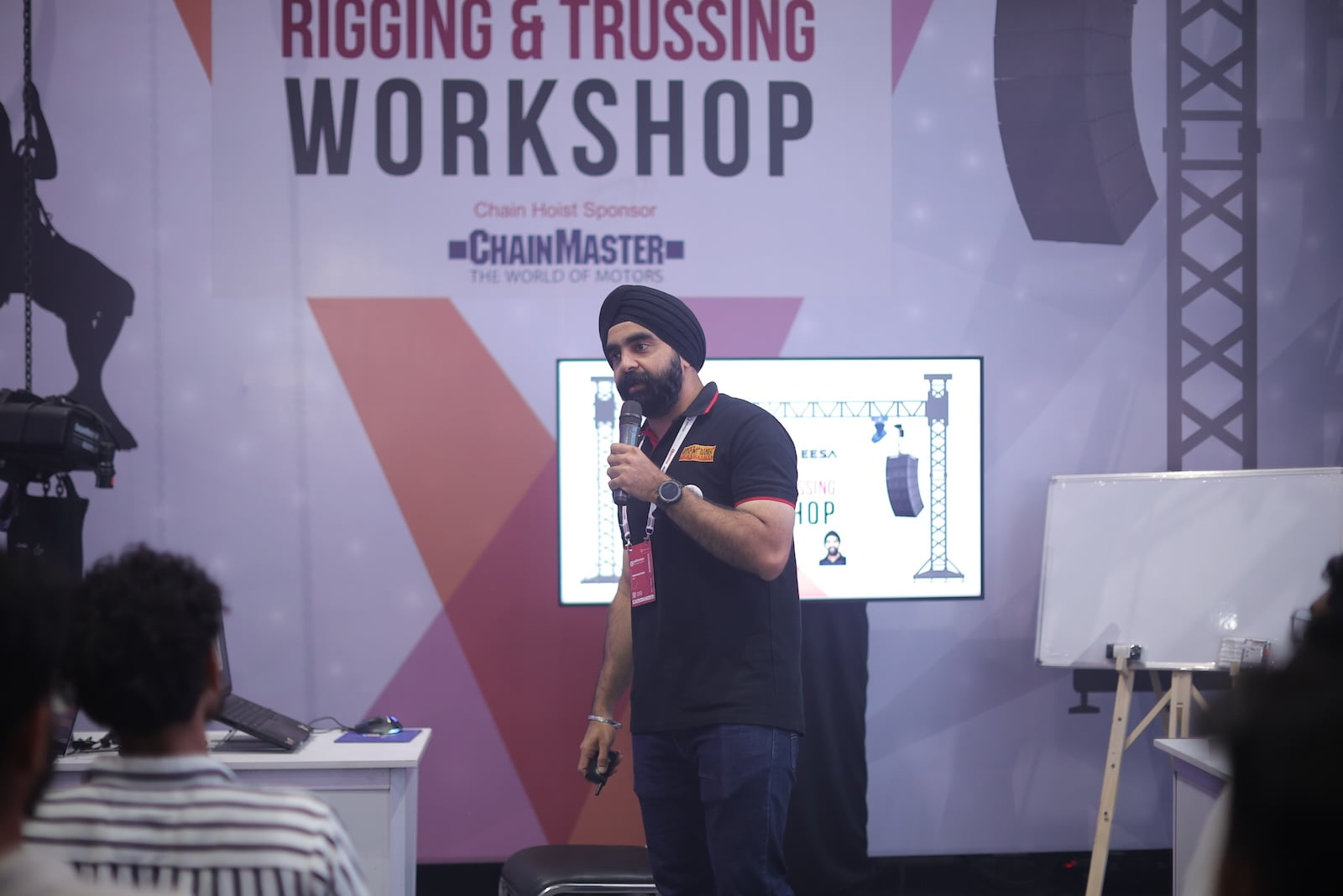Presenter presenting about safety techniques on stage at PALM Expo Live Rigging Workshop