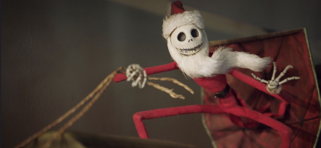 Jack Skellington figurine as Santa and is holding the reins of his sleigh.
