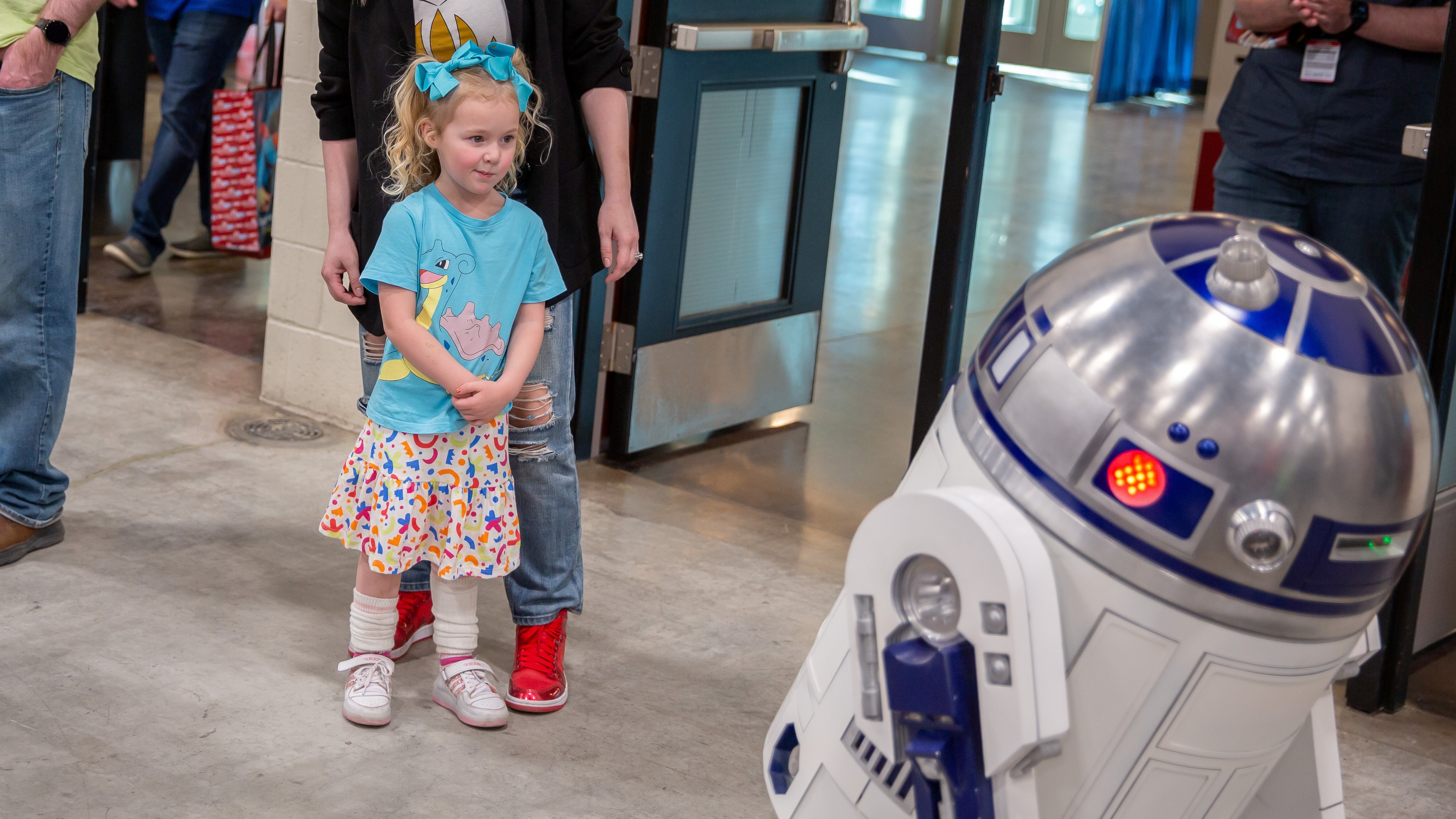 A young girl is staring at R2D2
