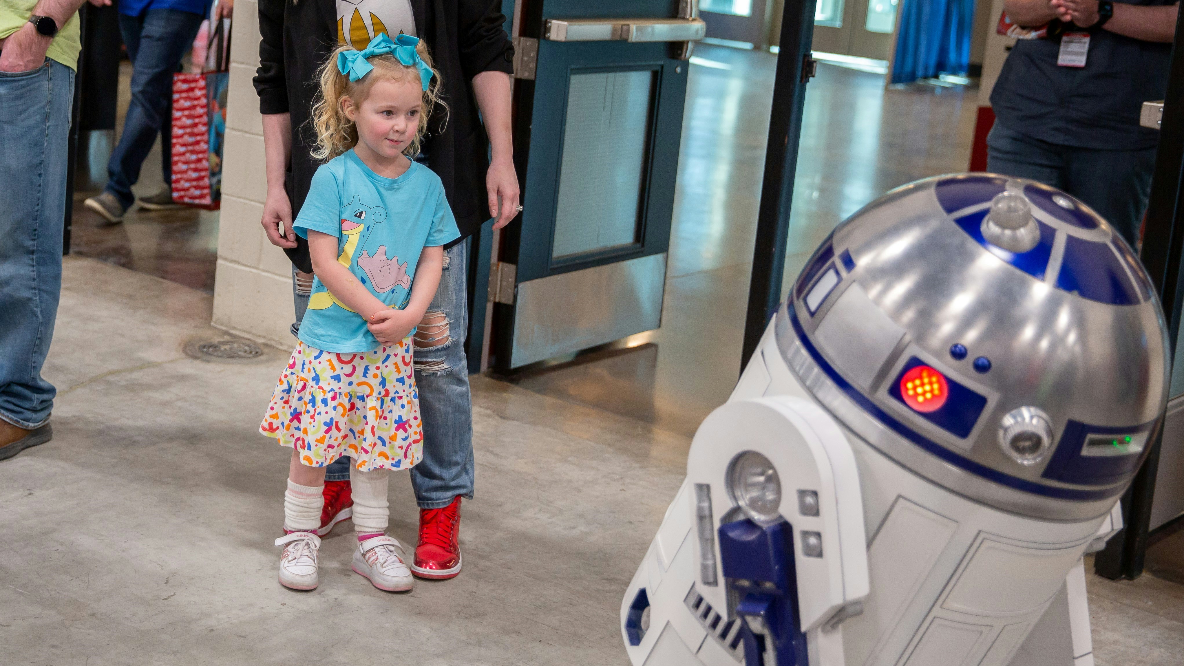 A young girl is staring at R2D2