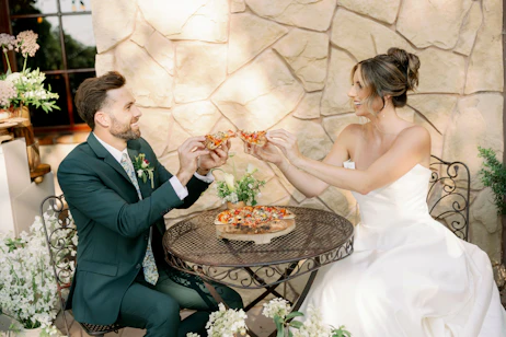 Bride and groom eating pizza at their wedding
