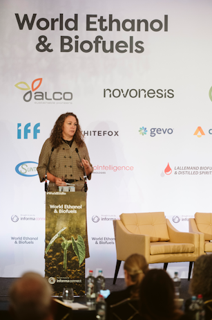 Keynote speaker at World Ethanol & Biofuels 2025 in Brussels with sponsor logos displayed, sharing insights on biofuels innovation.