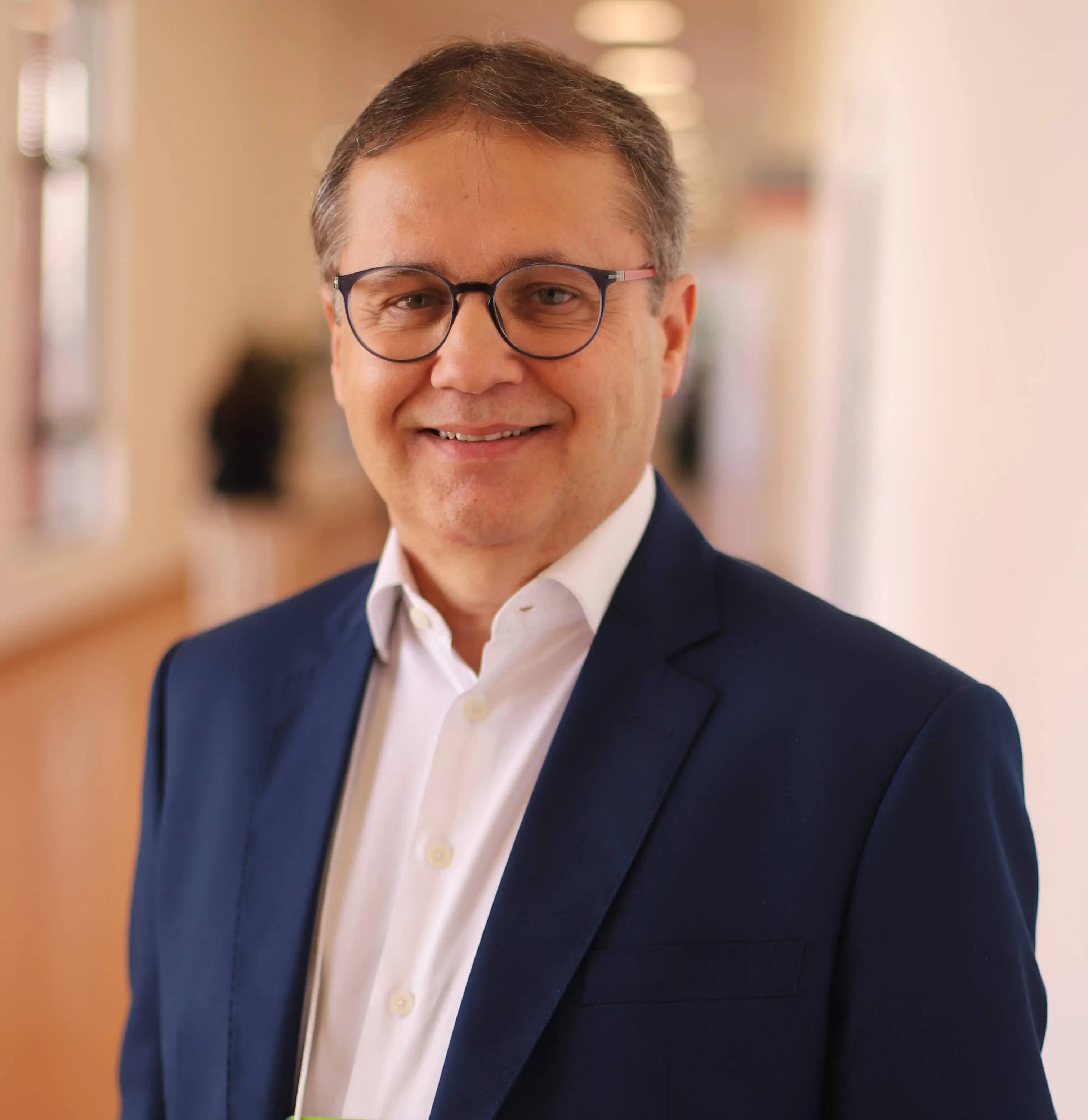 Robert Carletti, executivo convidado da Hospitalar, em foto de perfil profissional com fundo neutro, vestindo terno escuro.