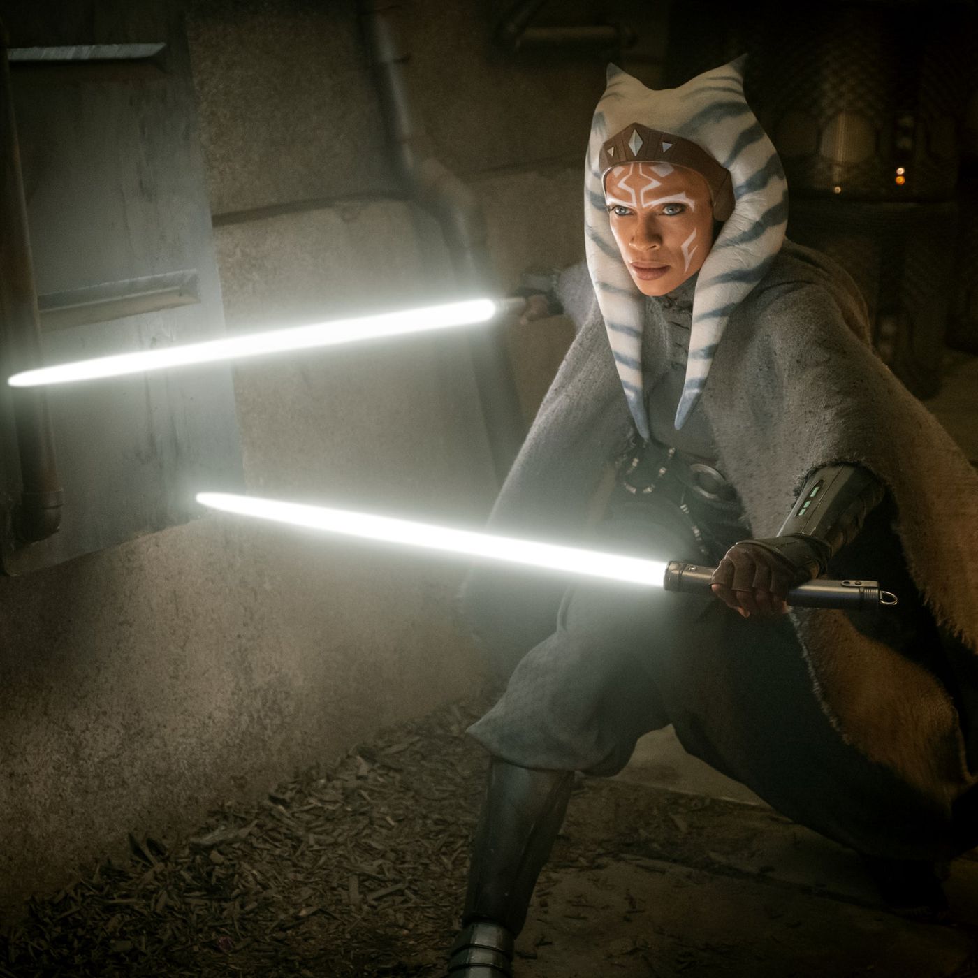 Ahsoka Tano from The Mandalorian mid-fight holds her white glowing lightsabers out ahead of it