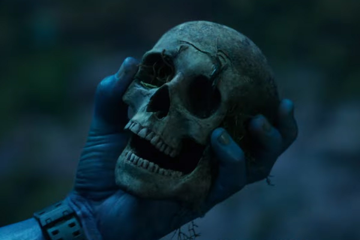 A blue Na'Vi hand holds a human skull