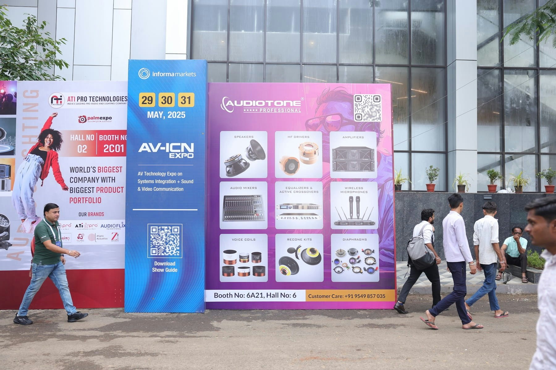 Outdoor view of PALM Expo venue entrance with large event signage and attendees walking in.