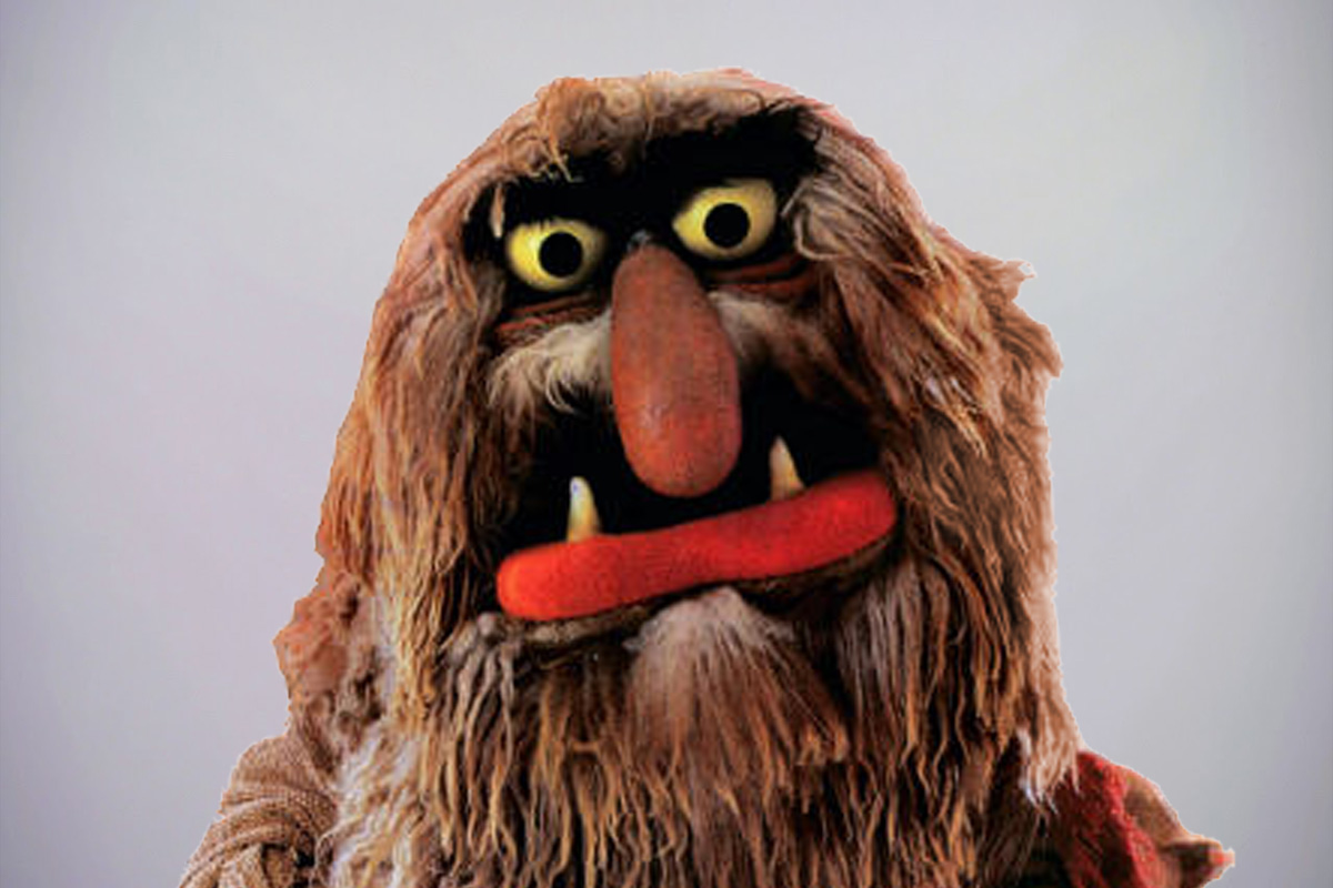 Muppets character Sweetums stands with an open mouth on a grey background