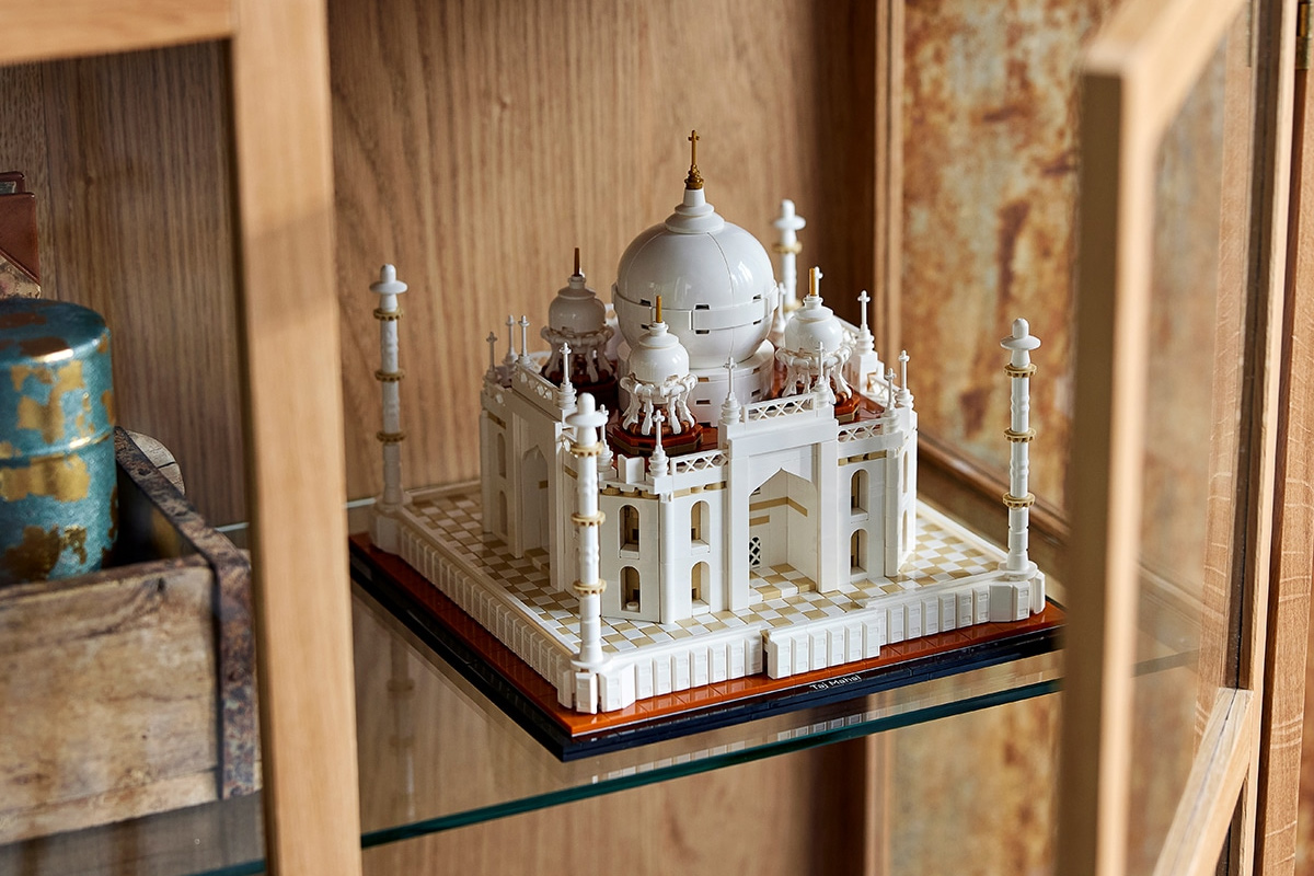 Lego of the Taj Mahal sitting on a glass shelf surrounded by wood