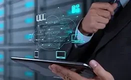 Especialista em TI segurando um tablet que projeta um holograma de rede em nuvem com os termos 'Platform', 'Application' e 'Infrastructure' (PaaS, SaaS, IaaS), em um ambiente de data center com servidores rack ao fundo.