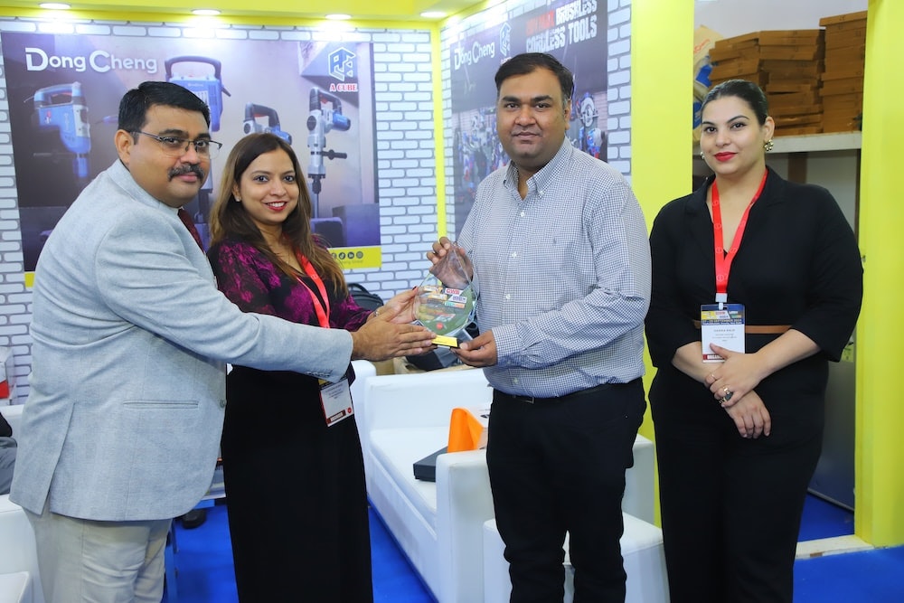 Show team presents an Excellence Award to an exhibitor at a tools stand.