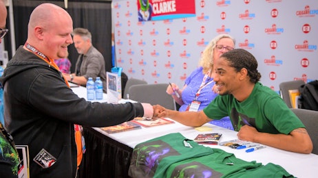 Nadji Jeter fist bumps a fan at his table