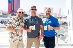 3 men posing for photo in front of the Vegas skyline at the public sector reception