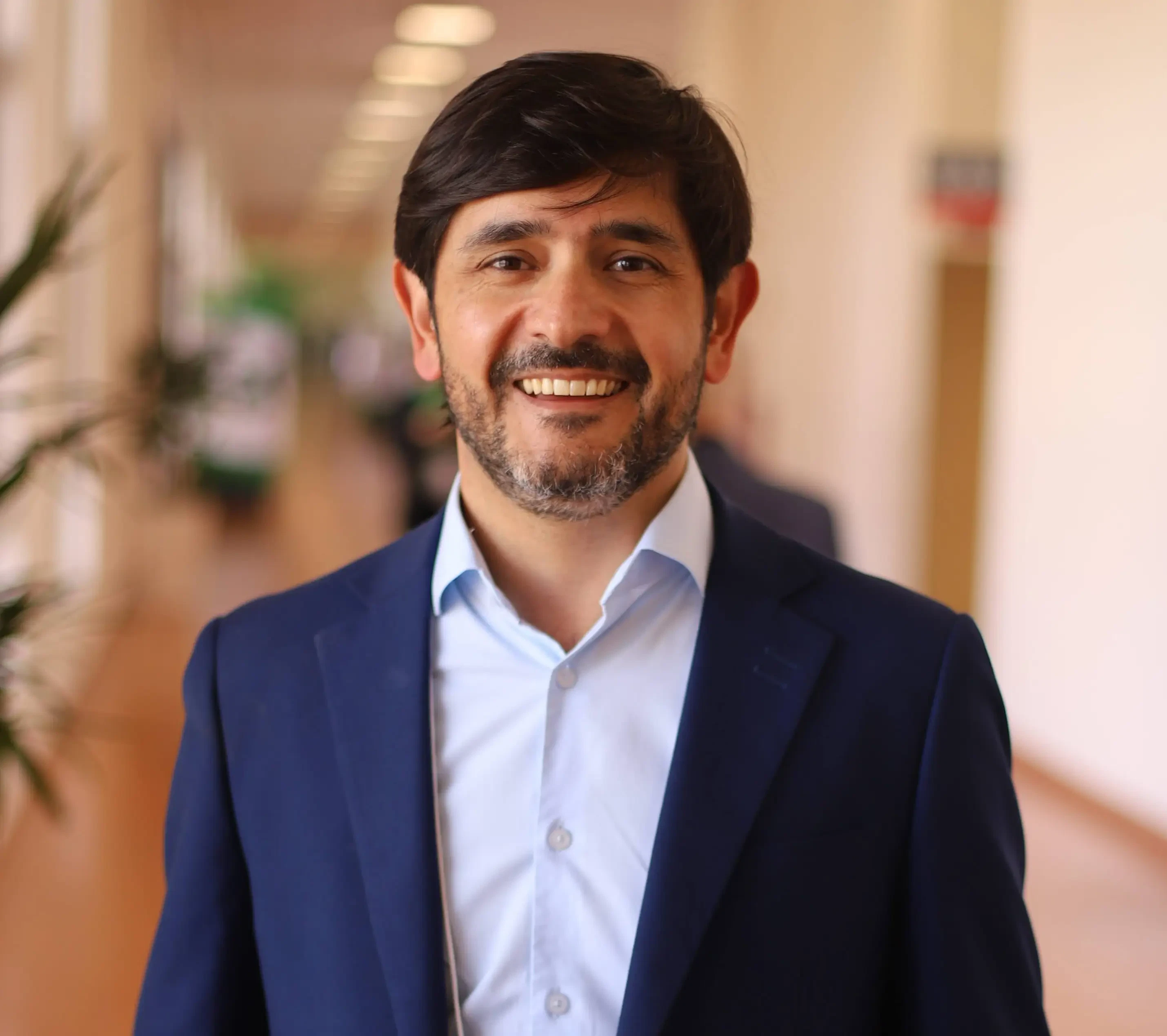 Walmor Brambilla, curador da Hospitalar 2026, em retrato profissional sorrindo, vestindo terno cinza e camisa azul clara.