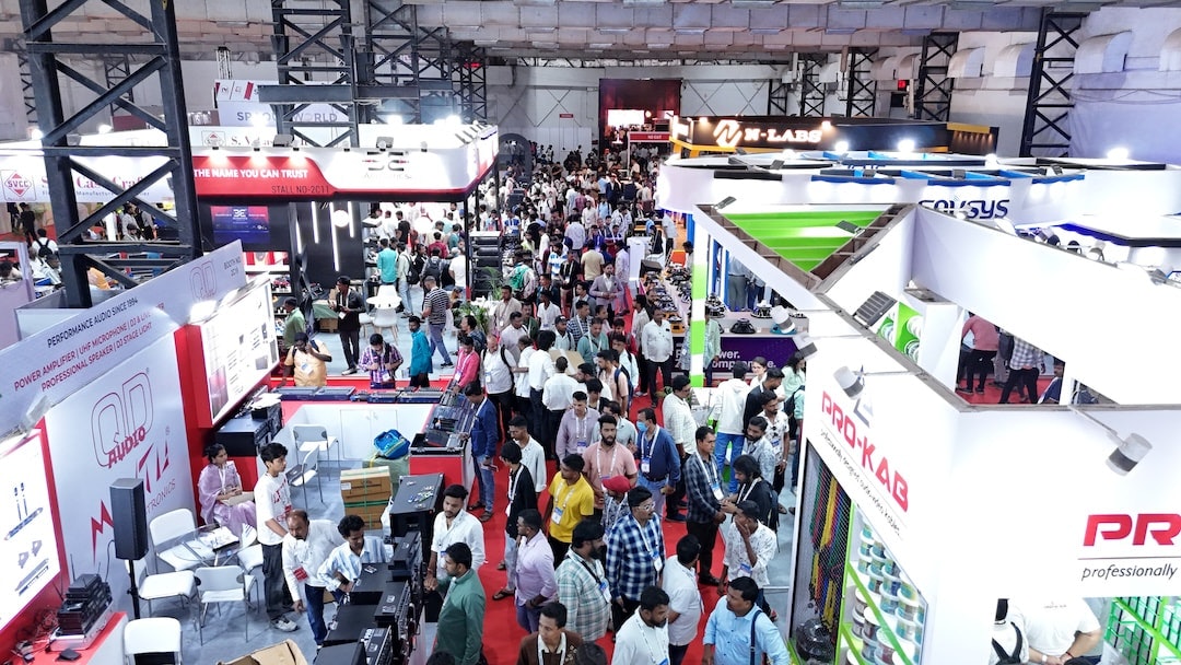 Aerial view of the exhibition area with multiple booths and attendees walking through the aisles