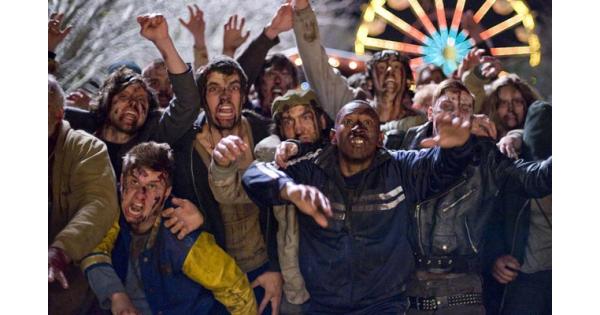 a hoard of zombies makes their way towards the camera, all in various states of groaning or snarling